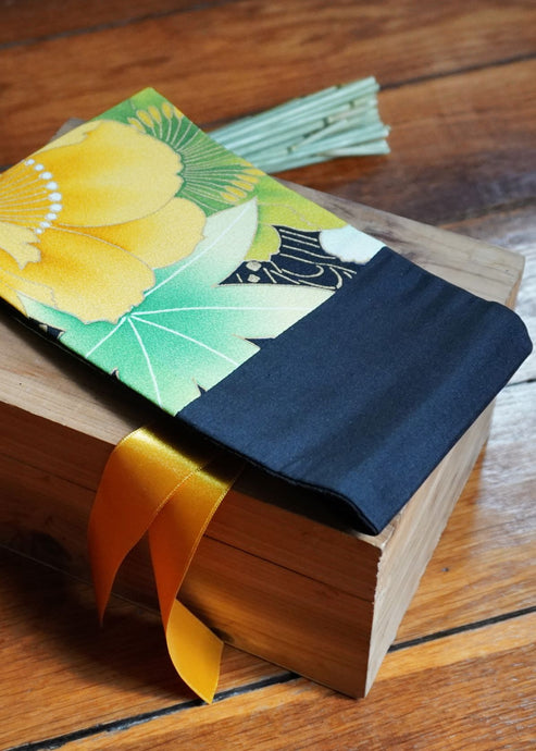 Ravissante ceinture de style obi, cet accessoire tendance, pièce incontournable de la garde-robe met la taille en valeur et affine la silhouette. Les côtés sont en soie noire, le tissu central de kimono représente une fleur jaune et le ruban de satin est jaune.