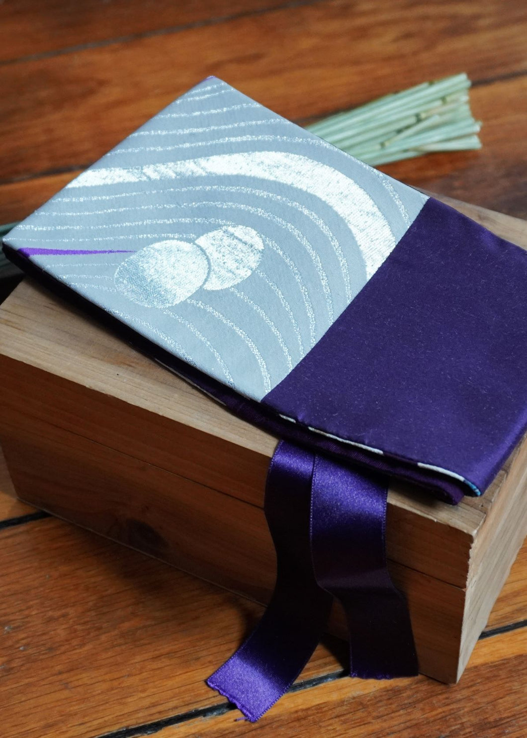 Ravissante ceinture de style obi, cet accessoire tendance, pièce incontournable de la garde-robe met la taille en valeur et affine la silhouette. Les côtés sont violet, de même que le ruban et le tissu central de obi est argent avec des motifs comme un jardin zen.